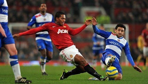 Manchester United's Antonio Valencia (L) goes for a 50-50 ball with Reading midfielder Jem Karacan, on February 18, 2013